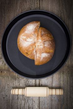 Loaf of bread cut in half on a black tray