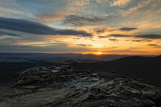 Blue Mountains sunsets across valleys and ridges with rocky outcrops