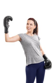 A portrait of a young beautiful girl with boxing gloves, raising one hand to celebrate her success, isolated on white background.