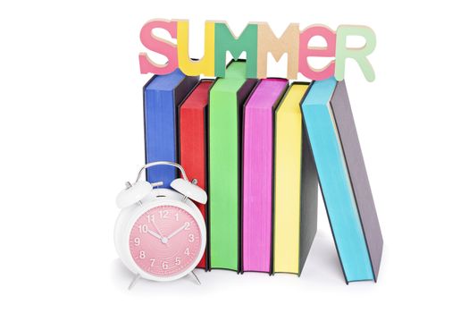 Summer, reading concept. Letters spelling SUMMER places over books with colorful sprayed edges and a clock, isolated on white background.