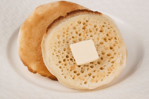 Delicious fresh British crumpets with a piece of butter