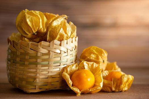Cape gooseberry in bamboo basket. Concept of health care or herb. Closeup and copy space for text.