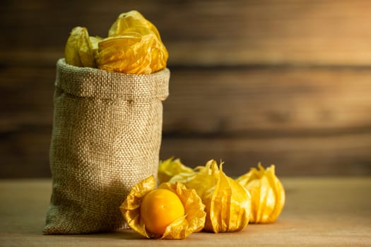 Cape gooseberry in burlap bags. Concept of health care or herb. Closeup and copy space for text.