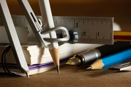 Compass for drawing and stationary on wooden table. Concept of architecture office or back to school. Closeup and copy space for text.