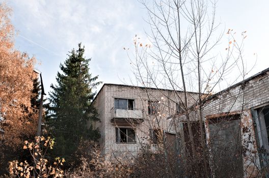 old abandoned brick house with a balcony and trees with a lamppost in Chernobyl Ukraine in autumn