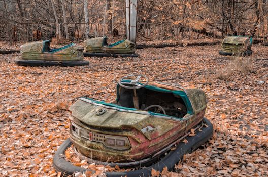 cars in an abandoned amusement park in Chernobyl Ukraine in autumn close up