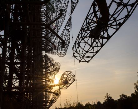 secret army antenna radar in the forest at sunset with sun rays in Chernobyl Ukraine in autumn