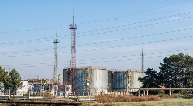 storage tanks of nuclear waste among green trees against a blue sky in Chernobyl Ukraine in the fall afternoon
