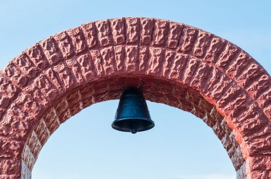 church christian bell with arch on a background of blue sky in Chernobyl Ukraine