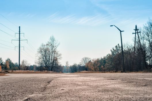 empty road to Chernobyl Ukraine trees and poles against the blue sky and clouds