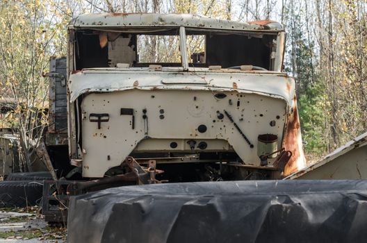 abandoned broken equipment car in the Chernobyl forest Ukraine in autumn