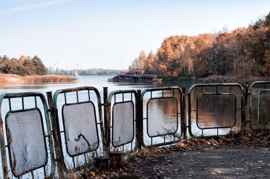 autumn landscape river and pier with a sunken destroyed house in Chernobyl in Ukraine