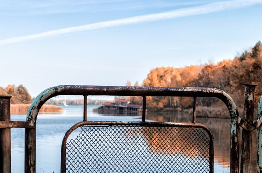 autumn landscape river and iron fence with a sunken destroyed house in Chernobyl