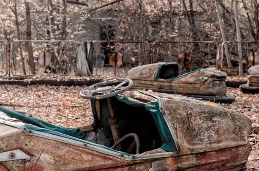 cars and nobody in an abandoned amusement park closeup in Chernobyl Ukraine