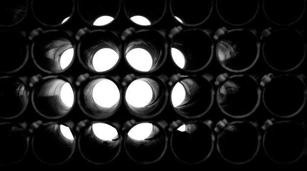 abstract dark black and white background of round pipes
