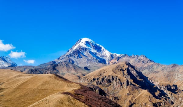 landscape high rocky mountains of the Caucasus in Georgia on a background of blue sky and clouds