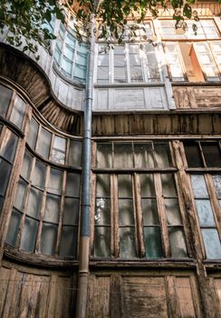windows of old tall house with green leaves of tree branch in  Georgia