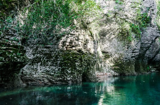 mountain river of high stone cliffs with green plants in the Martvili Canyon in Georgia in autumn