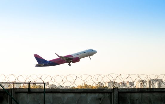 take off airliner over the city with a fence of barbed wire at the airport of Kiev Ukraine
