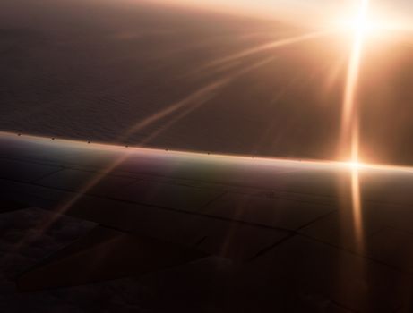abstract background rays and light of the rising sun and the wing of the plane with color optical effect