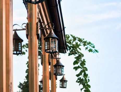 background vintage iron copper lanterns on the facade of the house with windows with a branch of grapes in Tbilisi Georgia afternoon autumn
