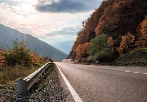 landscape mountain road and sky with sunbeams and clouds in Georgia in autumn