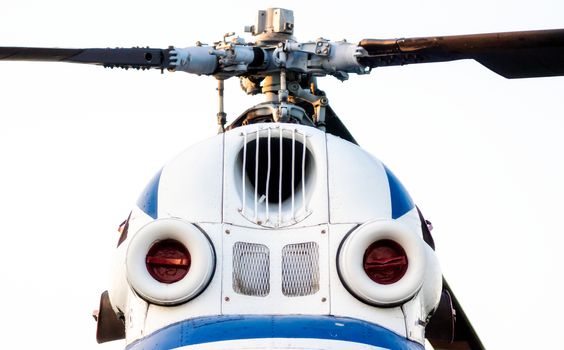 cockpit of an old white helicopter with propeller blades isolated close up