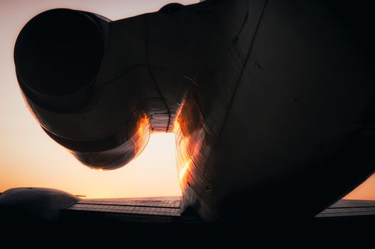 silhouette fragment turbine and wing of a large airliner on sunset background