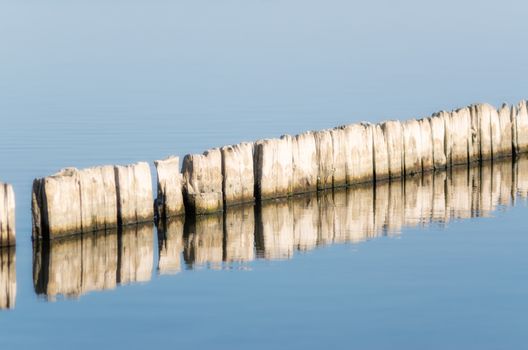 wooden stools hemp in calm water of the lake in the afternoon autumn