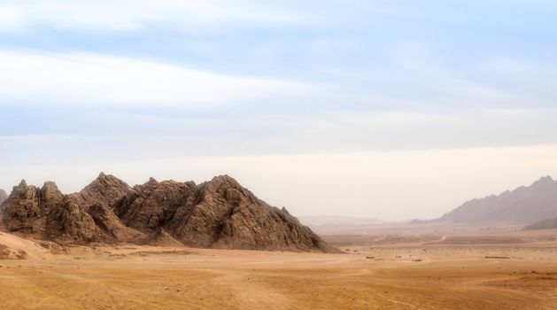 landscape of desert and high rocky mountains against the blue sky and clouds in Egypt in Sharm El Sheikh