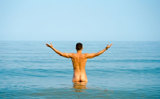 nude young man in blue water