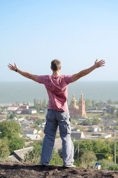 athletic man spread his arms over the cliff