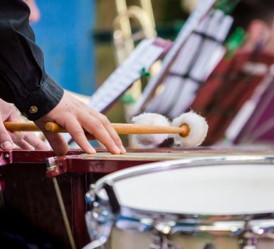 male musician drummer hands with drumsticks and drum closeup