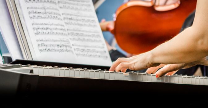 female hands of a pianist musician and piano keys closeup