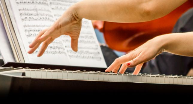 female hands of a pianist musician and piano keys closeup