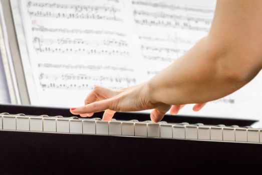 female hands of a pianist musician and piano keys closeup