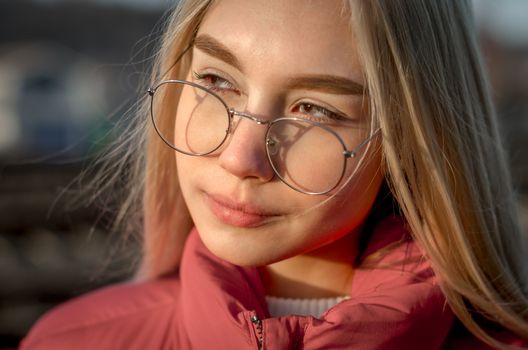 portrait of a young blonde girl with glasses close up