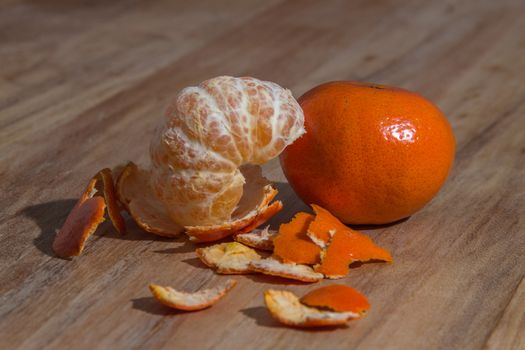 Peeled tangerine ready to eat over a wooden table