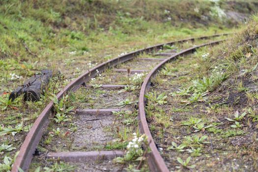 A disused historic narrow gauge railway with a right turn deflecting 
