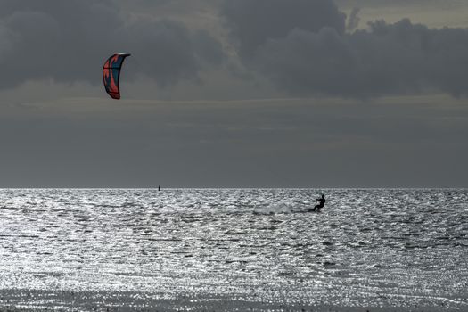 Sports kite surfer in the evening sun on the Wadden Sea near the island of Terschelling in the North of the Netherlands
