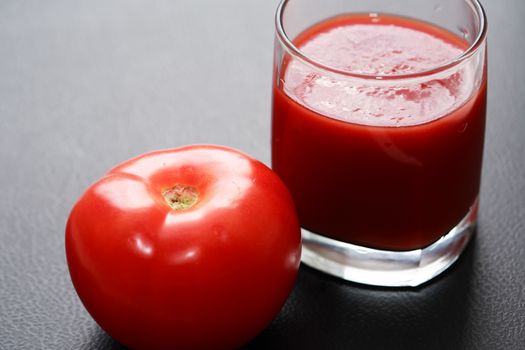 Full glass of tomato juice on nice gray background