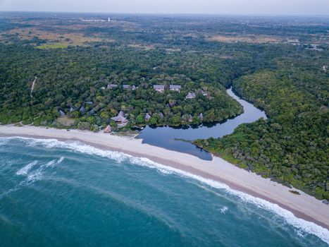 Drone picture of a hotel by a lagoon in a coastal forest on the Swahili Coast, Tanzania.
