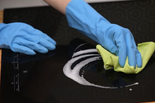 Woman Hands Cleaning A Modern Black Induction Hob