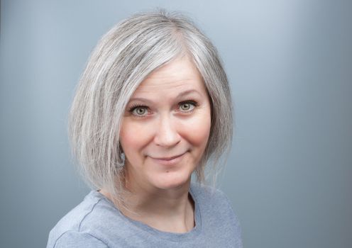 Portrait of an adorable woman with grey hair in her early fifties