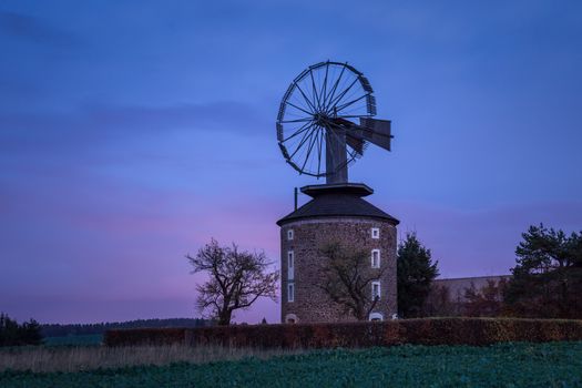 Spooky landscape with haunted wind mill at night. Moment after sunset. Windmill called Ruprechtov in Czech republic. Close to Moravsky Kras.