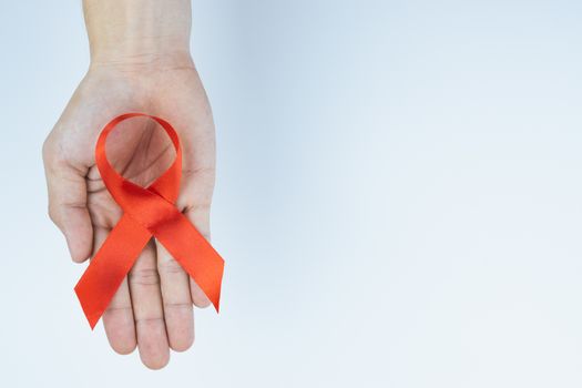 Aids awareness, male hands holding red AIDS awareness ribbon on white background. World Aids Day, Healthcare and medical concept.