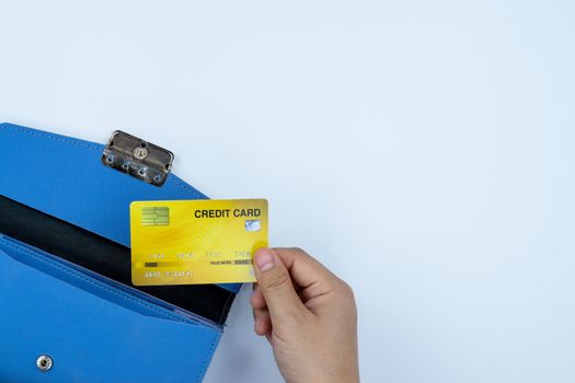 Woman hand taking out the credit card from blue purse for payment on the white background. Finance and money concept, top view, copy space for text.