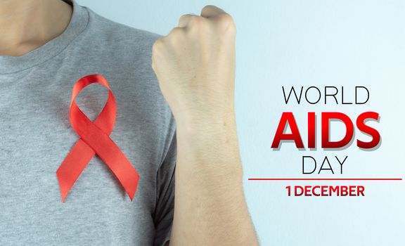 Aids awareness, male hands holding red AIDS awareness ribbon. World Aids Day, Healthcare and medical concept.