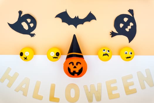 Top view of Halloween decoration, jack o lantern, ghost, bat and spider on yellow background with copy space for text. halloween concept.