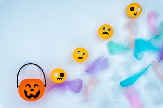 Top view of Halloween decoration, jack o lantern, ghost, bat and colorful feather on white background with copy space for text. halloween concept.